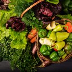 Assortment of vegetables and green herbs. Market. Vegetables in a basket on a dark background